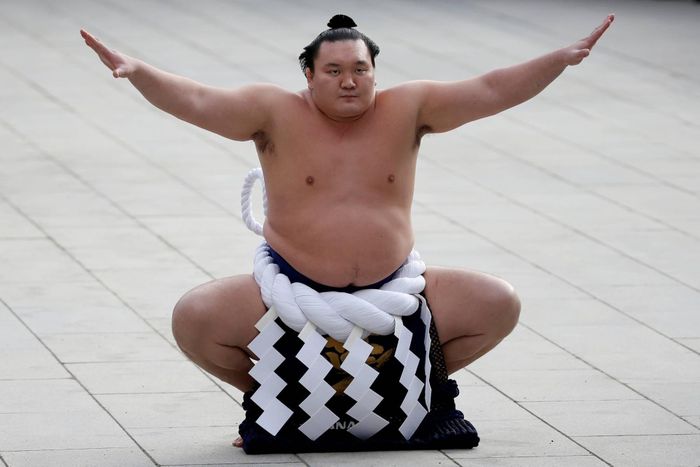 Hakuho Sho, cựu võ sĩ sumo hạng Yokozuna, đặt ngọn lửa lên đài trong lễ tiễn ngọn lửa ở Nagoya đêm 18/9, kết thúc hành trình rước đuốc. Ảnh: Reuters.