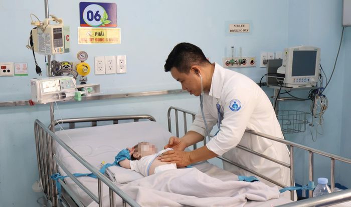 Bác sĩ Dư Tuấn Quy thăm khám cho bệnh nhi. Ảnh: Đ.H.