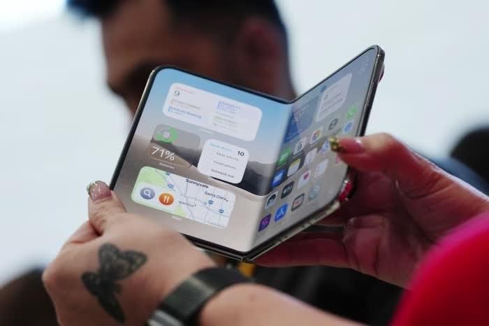  Một người cầm chiếc iPhone Duo trong sự kiện giới thiệu sản phẩm. Ảnh: Bloomberg. 