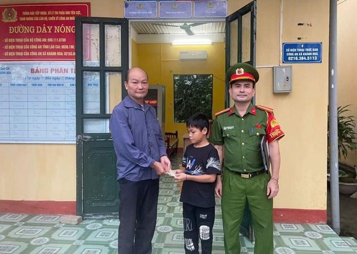 Em Trần Đình Giang trao trả chiếc ví cho ông Triệu Tiến Hương. Ảnh: Công an xã Khánh Hòa