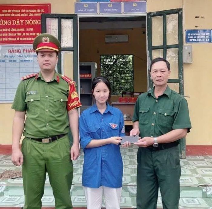 Ông Hoàng Văn Đôi trao trả chiếc điện thoại cho em Lý Thị Thanh. Ảnh: Công an xã Khánh Hòa