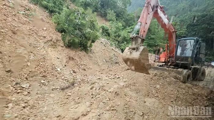 Phương tiện cơ giới tiếp tục xử lý điểm sạt lở trên Quốc lộ 15C lên các xã vùng cao, biên giới ở Thanh Hóa. (Ảnh: MAI LUẬN)