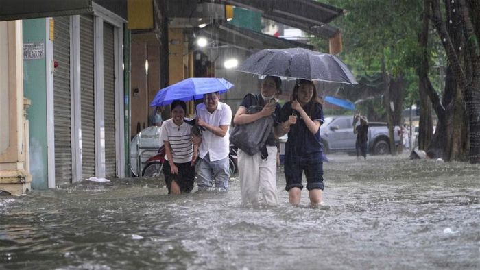 Nhiều người phải lội nước để về nhà. (Ảnh: ĐP)