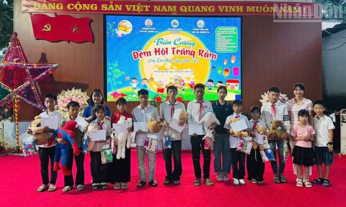 Các đơn vị tài trợ tặng quà cho học sinh xã Chiềng Khoong. (Ảnh: QUÀNG HÙNG)