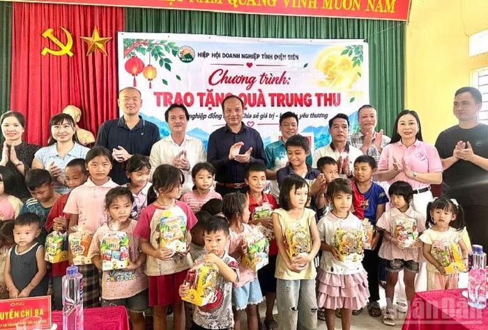 Ông Nguyễn Chí Ba, Phó Chủ tịch Hiệp hội Doanh nghiệp tỉnh Điện Biên cùng các doanh nghiệp thành viên Hiệp hội trao quà trung thu tặng các cháu học sinh bản Đề Chia, xã Pú Nhung. Ảnh: LÊ LAN