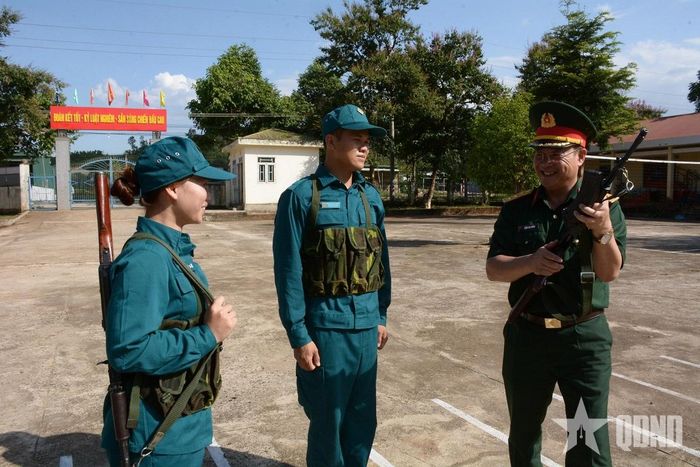 Chiến sĩ dân quân Mông Hải Quân (giữa) và Mông Thị Nhật Lệ trong khuôn viên đơn vị.