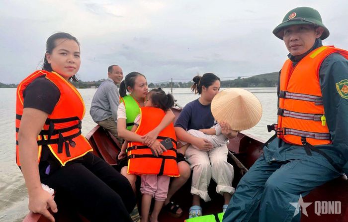  Người già, trẻ nhỏ được bộ đội đưa đến vị trí an toàn. Ảnh: KHÁNH TRÌNH 