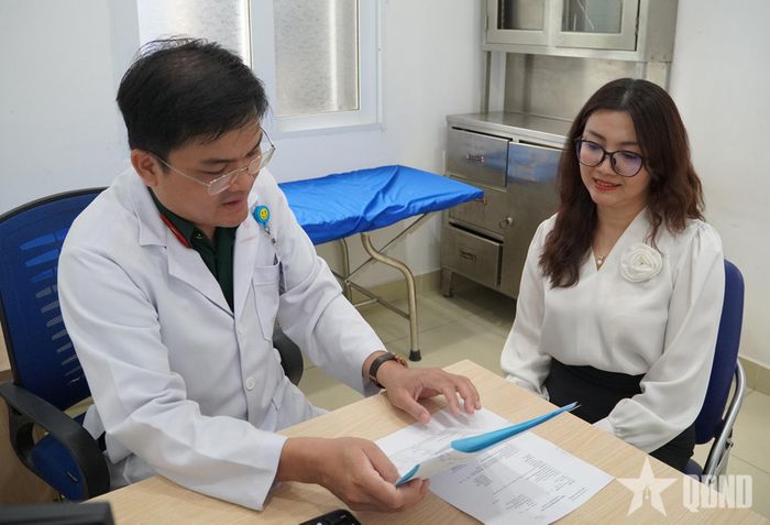 Thượng tá, Bác sĩ cao cấp, Bác sĩ Chuyên khoa II Phan Hữu Hùng kiểm tra hồ sơ bệnh án của bệnh nhân.