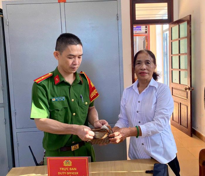 Bà Nhị bàn giao ví tiền nhặt được cho Công an xã Quế Sơn.