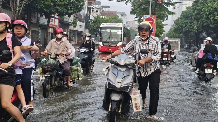  Phương tiện bị chết máy, người dân phải dắt bộ khi đi qua đoạn đường ngập. Ảnh: TIẾN CƯỜNG 