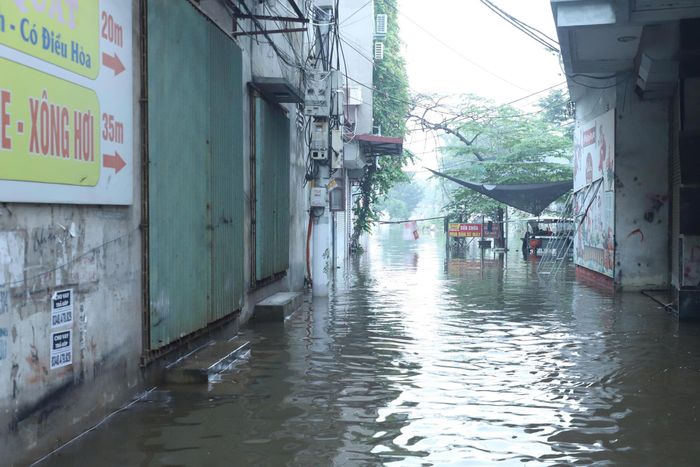  Nhiều ngõ ở dọc quốc lộ 32 cũng bị ngập sâu trong nước. Ảnh: TIẾN CƯỜNG 