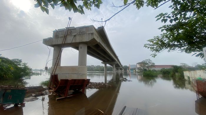  Cầu Tân Phú mới vẫn dở dang nhiều năm nay, cầu dân sinh (cầu cũ) thì bị ngập khiến người dân đi lại khó khăn 