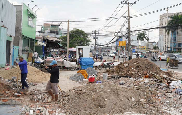Công nhân thu dọn phế liệu để bàn giao mặt bằng cho chủ đầu tư thi công dự án Nâng cấp, mở rộng quốc lộ 13. Ảnh: PHƯƠNG UYÊN