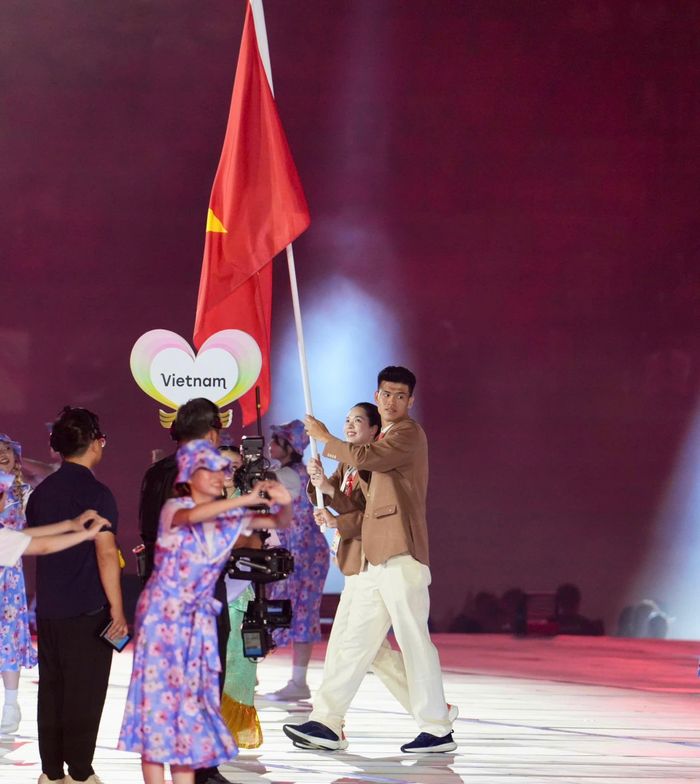  Trung vệ Đinh Quang Kiệt cùng chủ công Lê Thanh Thuý đại diện thể thao Việt Nam cầm cờ lễ khai mạc. ẢNH: VIETCONTENT 
