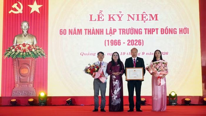 Bà Lê Thị Hương, Giám đốc Sở GD&ĐT trao Bằng khen của UBND tỉnh cho Trường THPT Đồng Hới.