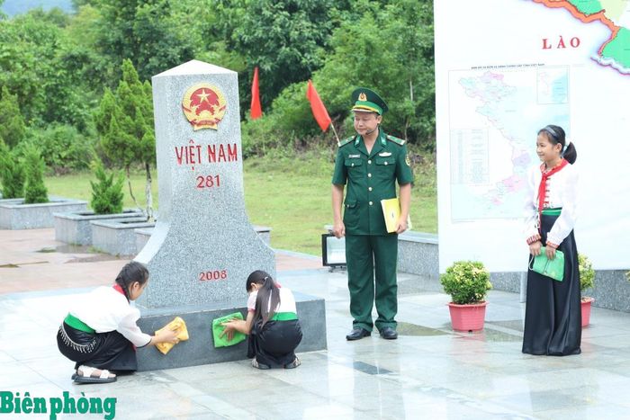 Dưới sự hướng dẫn của cán bộ, chiến sĩ, các em học sinh trải nghiệm vệ sinh mốc quốc giới 281. Ảnh: Tuấn Kiệt