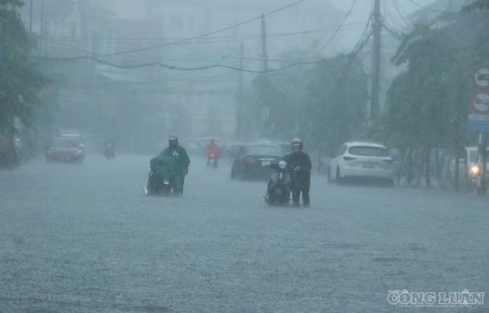 Mưa lớn đã ảnh hưởng đến việc đi lại, sinh hoạt của người dân. Ảnh: Kim Long