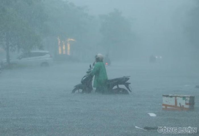 Đường ngập sâu nên nhiều người dân phải dắt bộ phương tiện. Ảnh: Kim Long
