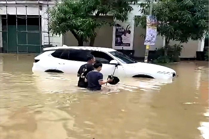 Một số ô tô chết máy khi đi qua vùng ngập, phải nhờ xe cứu hộ hỗ trợ.