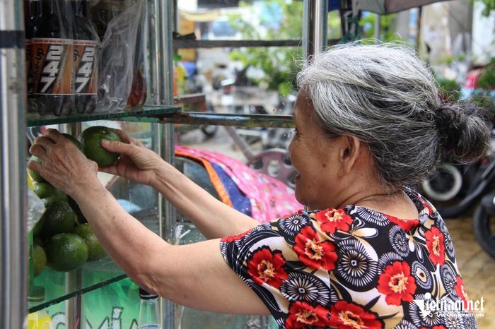 Bà Nguyệt xếp lại tủ nước giải khát sau cơn mưa lớn vào giữa trưa. Ảnh: Hà Nguyễn