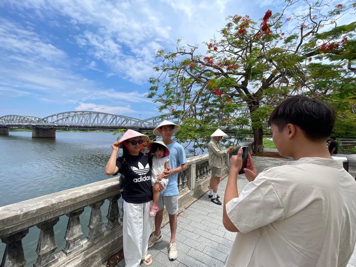 Anh Trần Hữu Huấn (ở Vũng Tàu) chụp ảnh kỷ niệm chuyến du lịch cùng vợ và con gái. Ảnh: Lê Bằng