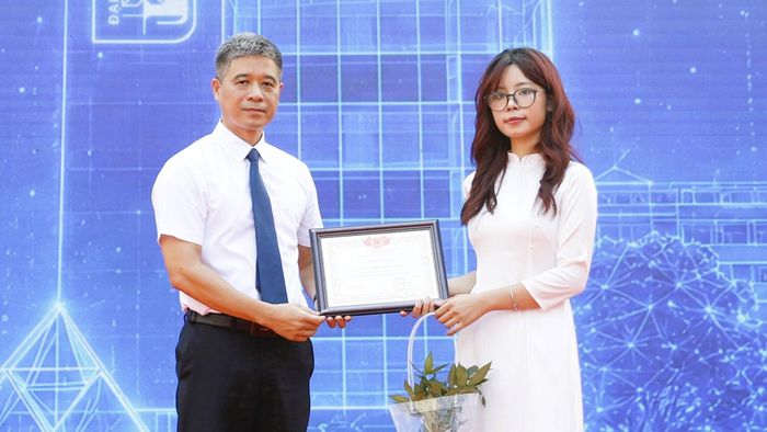 PGS.TS Hoàng Tùng, Hiệu trưởng Trường ĐH Xây dựng Hà Nội trao giấy khen, tuyên dương sinh viên tiêu biểu khóa 71 cho Phạm Minh Trang tại chương trình Chào tân sinh viên năm 2026. Ảnh: T.H