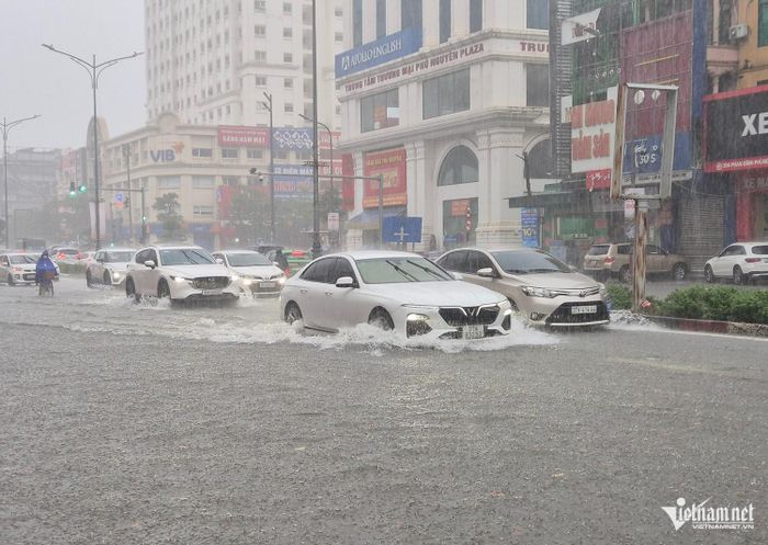 Người dân chật vật di chuyển qua đoạn ngập sâu trên đường Phan Đình Phùng. Ảnh: V.Đ