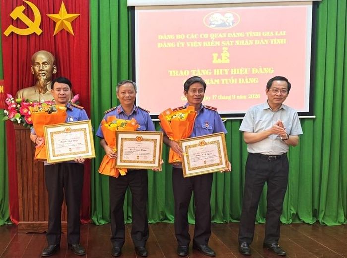 Đồng chí Đỗ Tiến Đông - Phó Bí thư chuyên trách Đảng uỷ các cơ quan Đảng tỉnh Gia Lai trao Huy hiệu Đảng cho 3 đồng chí trong VKSND tỉnh.