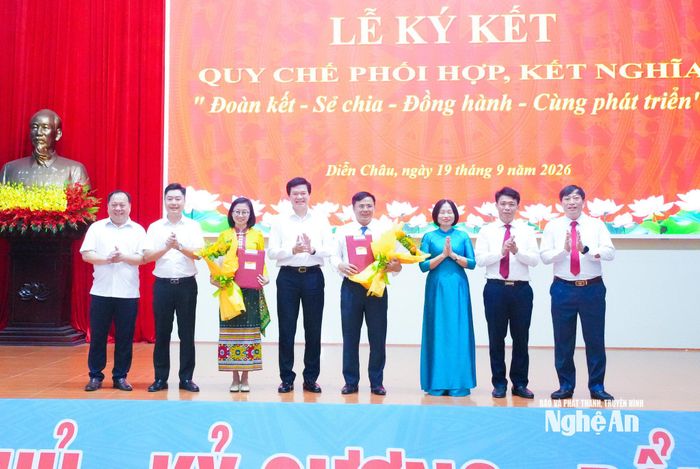 Đồng chí Nguyễn Đình Hùng - Ủy viên Ban Thường vụ Tỉnh uỷ, Phó Chủ tịch Thường trực Uỷ ban MTTQ Việt Nam tỉnh tặng hoa chúc mừng 2 địa phương ký kết phối hợp. Ảnh: Mai Hoa