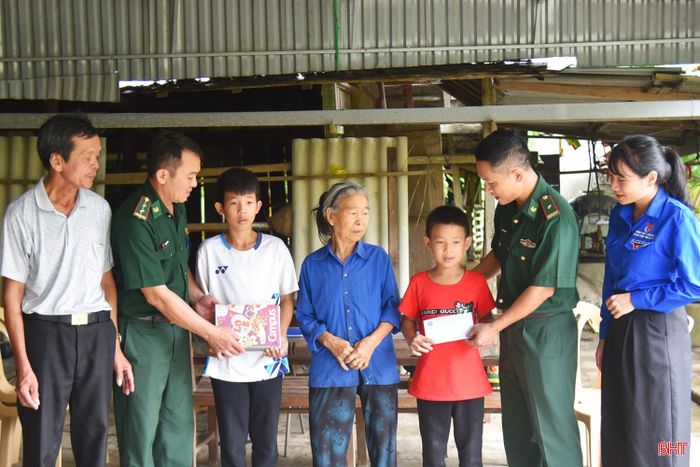 Đồn Biên phòng Sơn Hồng trao học bổng và tặng sách vở cho hai anh em Nguyễn Thế Hưng và Nguyễn Bảo Thịnh.