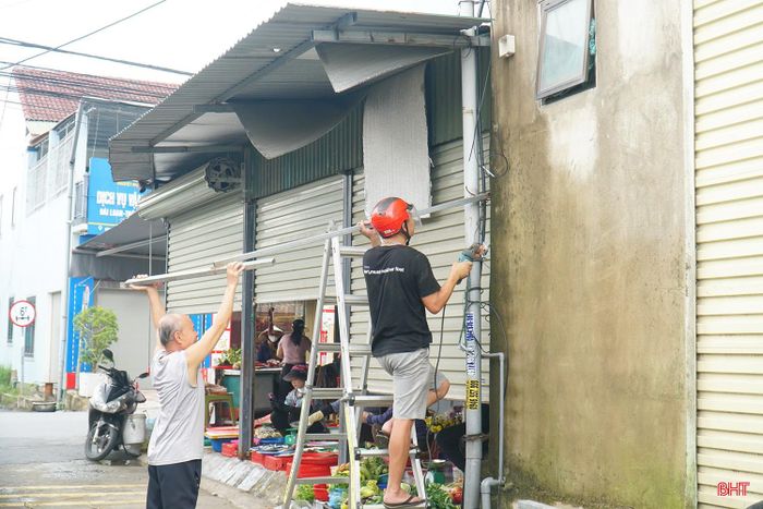 Lực lượng chức năng phường Hà Huy Tập tuyên truyền, vận động các hộ dân tháo dỡ mái che lấn chiếm lòng đường tại TDP 3.