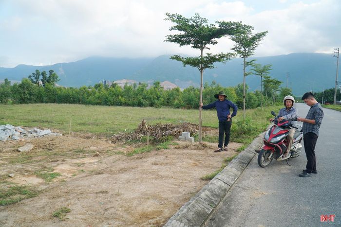 Ông Trần Đình Biên (áo đen, bên trái) trao đổi về công trình xây dựng của mình.