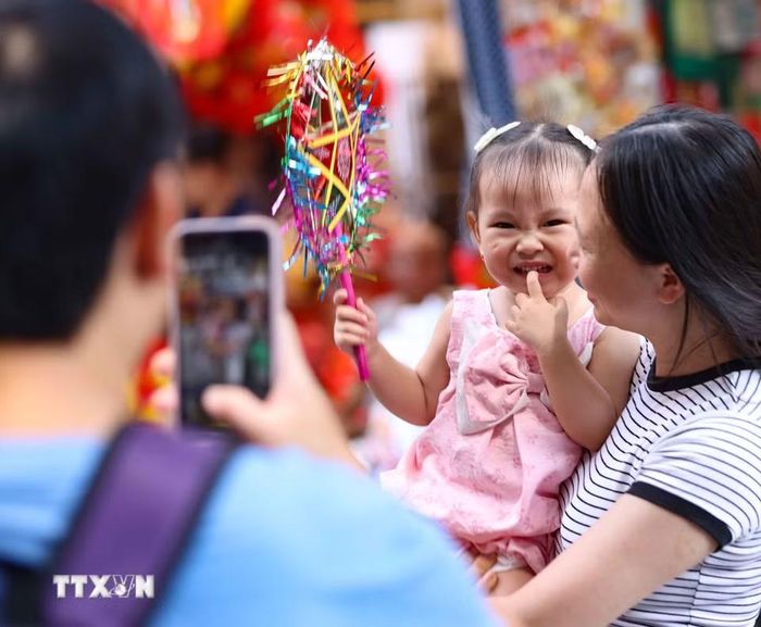 Lưu lại khoảnh khắc đẹp trong không khí rực rỡ sắc màu của chợ Trung Thu truyền thống. (Ảnh: Thanh Tùng/TTXVN)