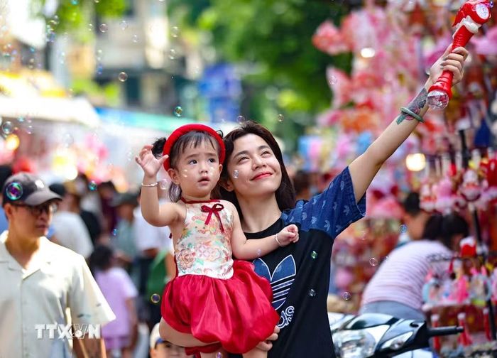 Trẻ vui tươi khi được hòa mình vào không khí rực rỡ sắc màu Trung Thu trên phố Hàng Mã. (Ảnh: Thanh Tùng/TTXVN)