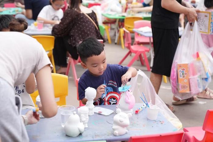 Em nhỏ chăm chú tô tượng. (Ảnh: PV/Vietnam+)