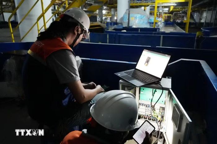 Chuyên gia nước ngoài cài đặt phần mềm điều khiển hệ thống xử lý hành lý nhà ga hành khách sân bay Long Thành. (Ảnh: Công Phong/TTXVN)