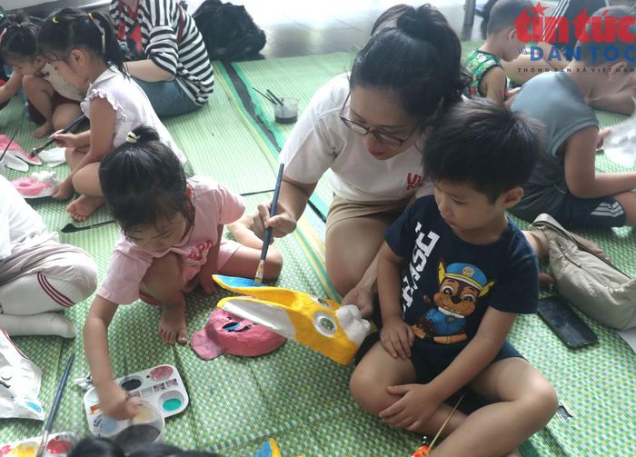 Phụ huynh hướng dẫn các em nhỏ vẽ mặt lạ giấy bồi.