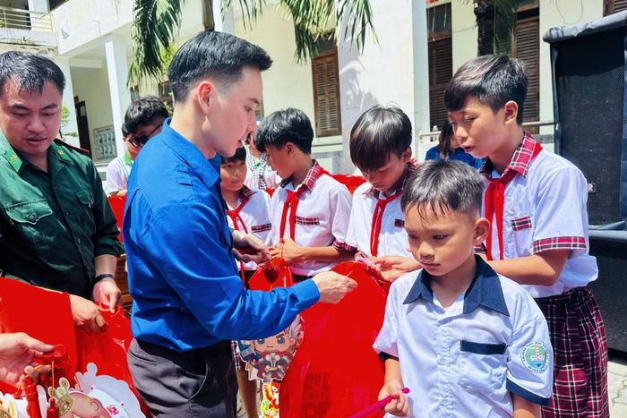 Anh Huỳnh Long Hồ, Bí thư Đoàn cơ sở Trung tâm Thông tin TTXVN khu vực phía Nam, trao quà Trung thu cho các em thiếu nhi.