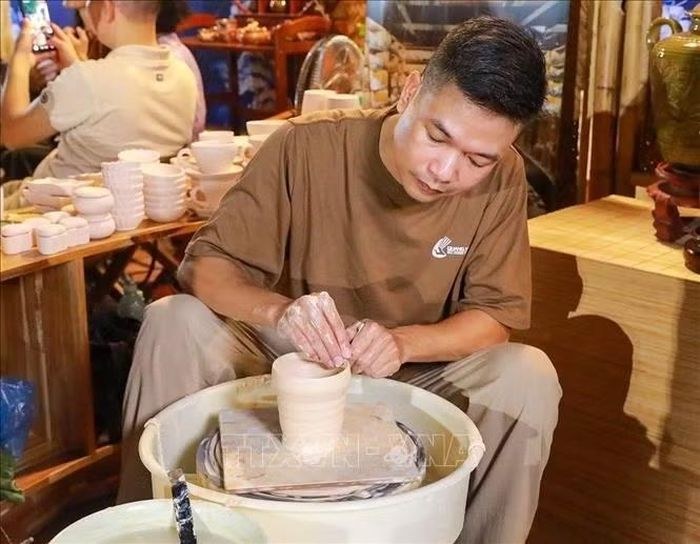 Nghệ nhân làng gốm Bát Tràng trực tiếp làm sản phẩm tại chương trình. Ảnh: Khánh Hoà/TXVN