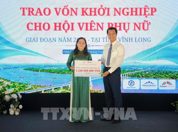 Tiếp nhận bản tượng trưng kinh phí hỗ trợ điểm khởi nghiệp không vốn. Ảnh: Huỳnh Phúc Hậu - TTXVN