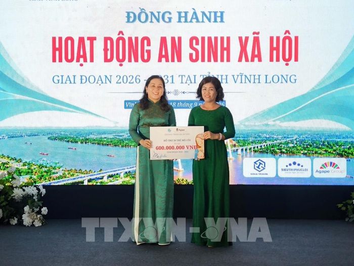 Tiếp nhận bảng tượng trưng hỗ trợ kinh phí thực hiện an sinh xã hội tại địa phương. Ảnh: Huỳnh Phúc Hậu - TTXVN