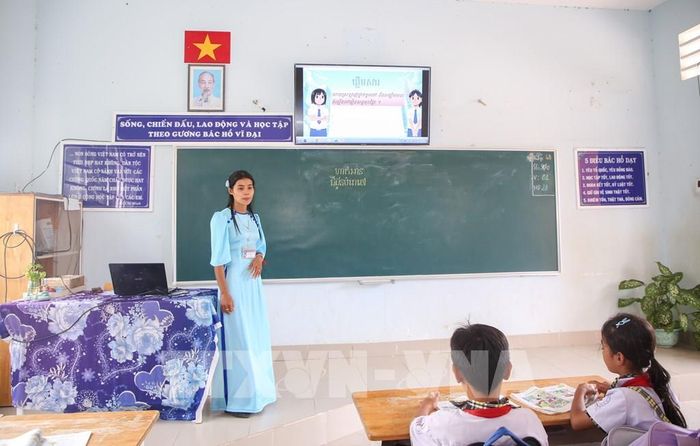 Việc kết hợp hình ảnh trực quan và công nghệ giúp học sinh Trường Tiểu học Hòa Đông dễ tiếp cận từ ngữ, nội dung bài học tiếng Khmer. Ảnh: Giang Phương - TTXVN