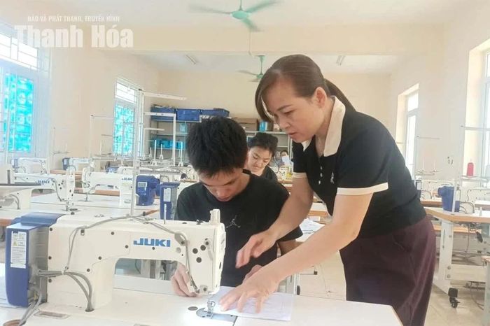 Cô giáo Hoàng Thị Hợp hướng dẫn học sinh học cắt may.