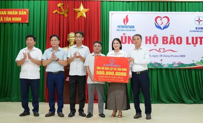 Đại diện Tập đoàn Điện lực Việt Nam trao biểu trưng hỗ trợ 500 triệu đồng cho xã Tân Ninh.