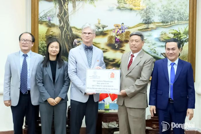 Đại sứ Pieter Leenknegt trao bảng biểu trưng hỗ trợ 20 triệu đồng đến Hội Nạn nhân chất độc da cam/dioxin thành phố Đồng Nai. Ảnh: Văn Truyên