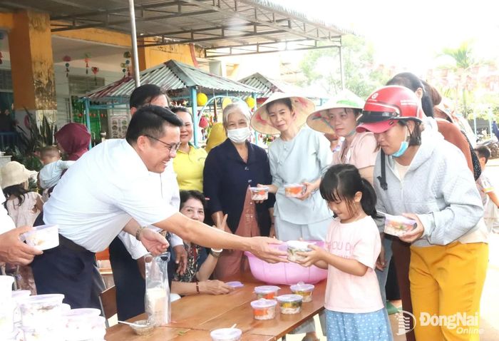 Lãnh đạo xã Đak Nhau và các phật tử tặng suất ăn chay miễn phí cho trẻ em và người dân trên địa bàn xã. Ảnh: Quang Minh