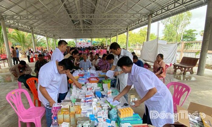 Các thành viên trong Đoàn công tác phát thuốc miễn phí cho người dân Campuchia.
