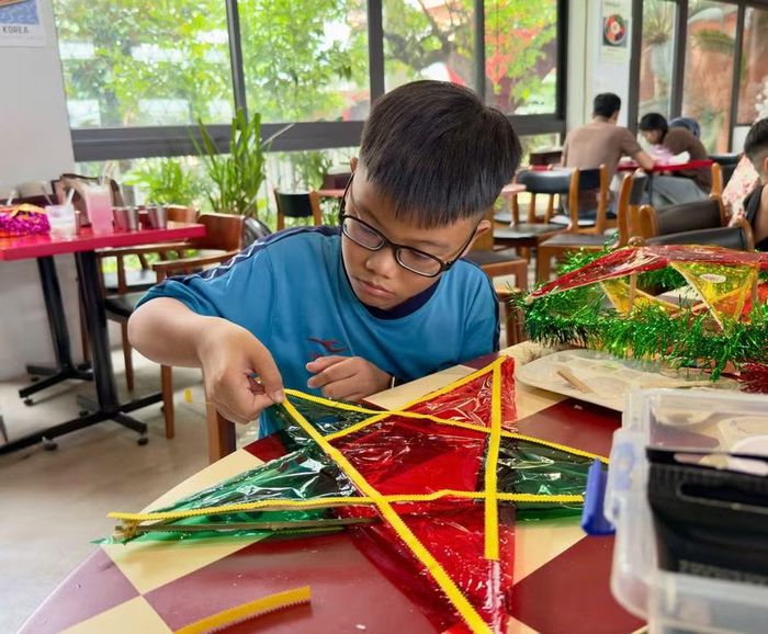  Em Trần Viết Khôi tự tay chăm chút cho chiếc lồng đèn ông sao handmade của mình. Ảnh: D.L 