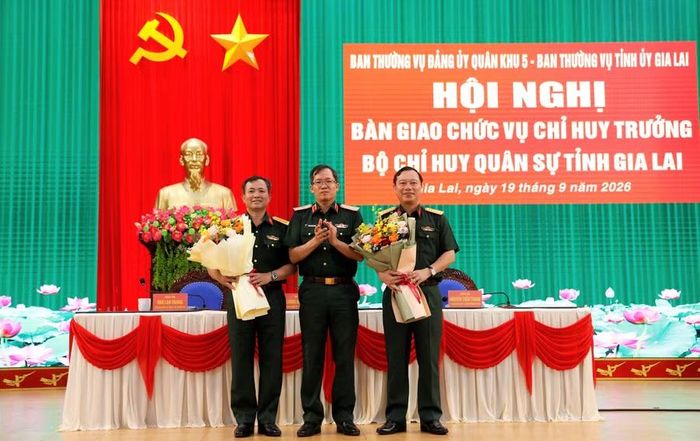 Thiếu tướng Lương Đình Chung - Chính ủy Quân khu 5 (giữa) tặng hoa chúc mừng Đại tá Nguyễn Thế Vinh (bên trái) và Đại tá Trần Thế Phan nhận nhiệm vụ mới. Ảnh: H.P