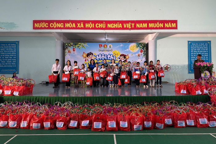 Đồng chí Mai Thị Xuân Trung, Tỉnh uỷ viên, Phó Chủ tịch HĐND tỉnh (áo dài xanh ở giữa) trao tặng học bổng cho các em thiếu nhi vượt khó trong học tập